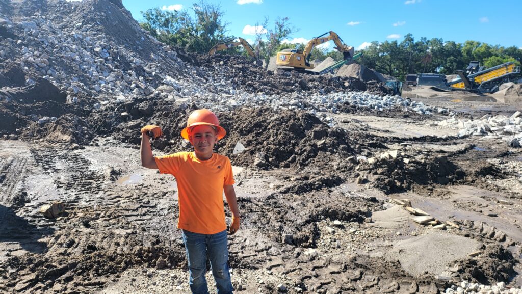 Family-owned junk removal and demolition team standing in front of company truck